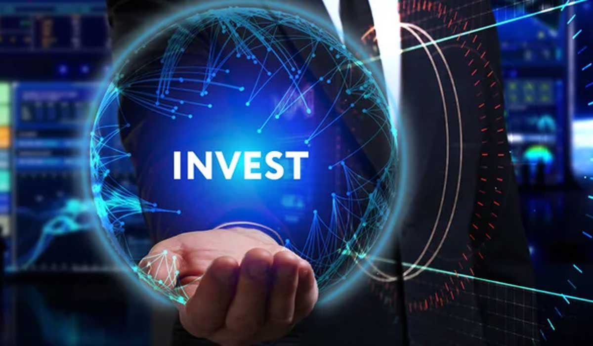 A person holds a glowing sphere with the word "INVEST" against a backdrop of digital financial charts and data.